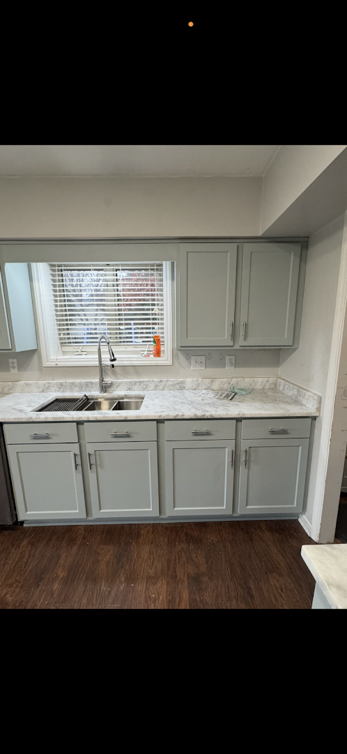 Light gray shaker-style kitchen cabinets with a white marble-look countertop