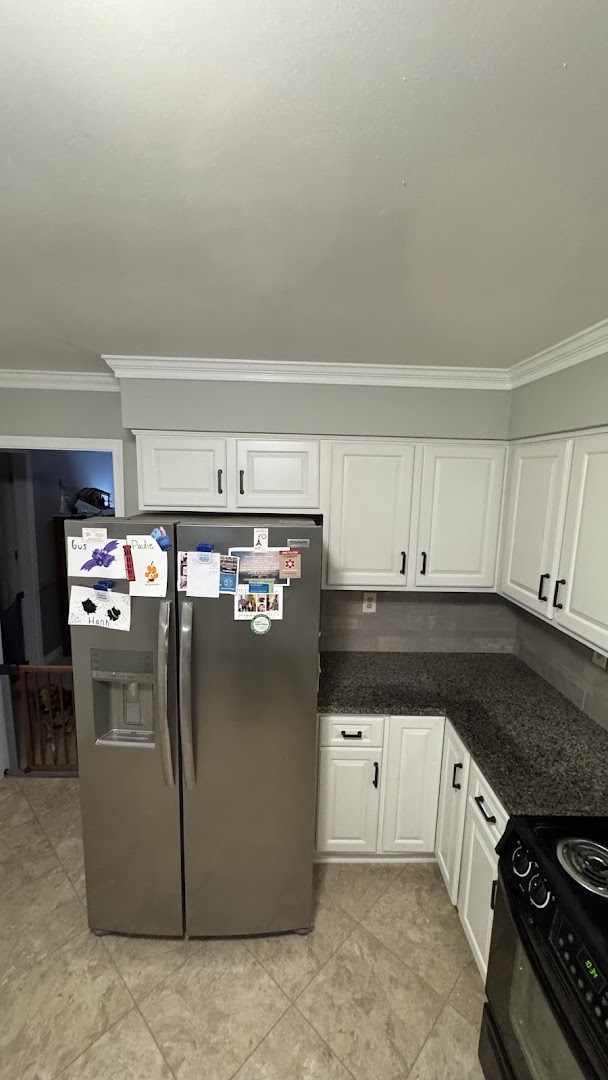 White kitchen cabinets with dark countertops and black hardware