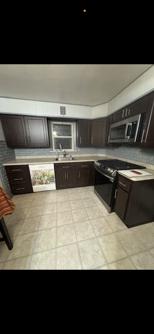 Dark brown kitchen cabinets with a gray subway tile backsplash