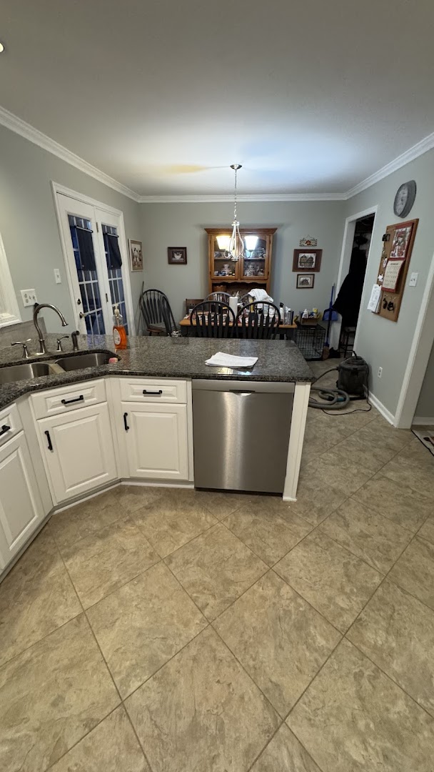 White kitchen cabinetry and island opening toward a dining area